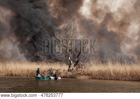 Disaster. Fire In National Park. Burning Reeds On River. Thick Black Smoke Pollutes The Atmosphere.
