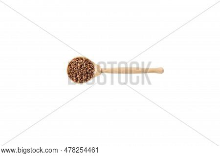 Dried Coriander Seeds In Wooden Spoon On White Background.
