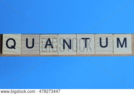 Word Quantum Made From Wooden Gray Letters Lies On A Blue Background