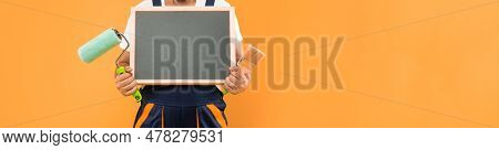 Cropped Man Housepainter In Work Clothes Hold Paint Roller Brush And Blackboard With Copy Space