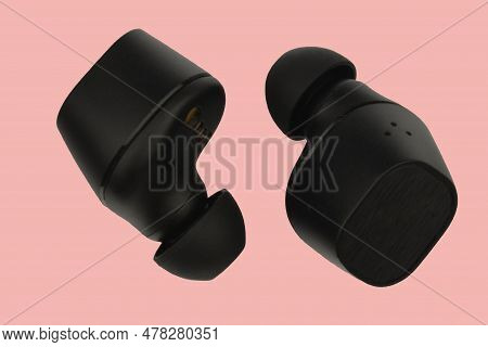 Wireless Stereo Earbuds. Black Wireless Earphones. Earbuds Or Headphones Isolated On Pink Background