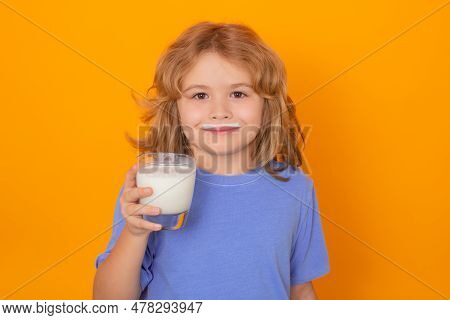 Kid Drink Fresh Milk. Child With A Glass Of Milk On Studio Background. Cute Boy In White Shirt Holdi