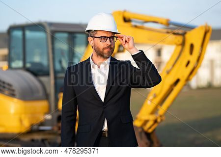 Construction Manager In Suit And Helmet At A Construction Site. Construction Manager Worker Or Super