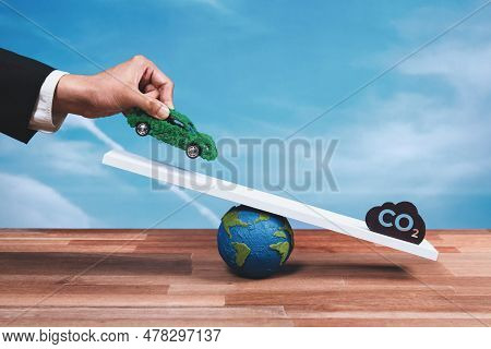 Businessman Weighs Eco-friendly Ev Car On Scale Against Co2 Symbol, Promoting Corporate Zero-emissio