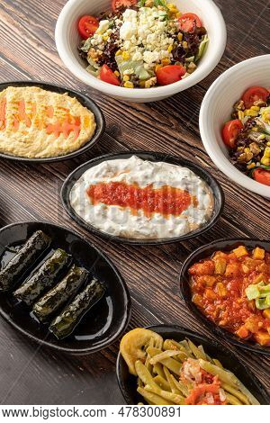 Mixed Turkish Appetizers On Wooden Table. Turkish Mezze. Such As Stuffed Leaves, Humus
