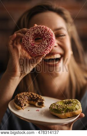 Young Happy Woman Posing With Donuts In A Cafe.