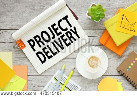 Project Delivery A Cup Of Coffee And A Notebook With Tools And Notes With The Text