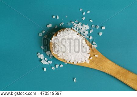 Coarse Salt Crystals On A Blue Table. Wooden Spoon With Sea Salt.