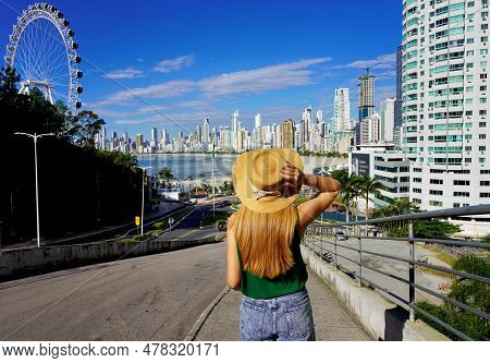 Holidays In Brazil. Rear View Of Young Woman With Hat Enjoying Balneario Camboriu City Skyline, Sant