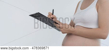 Pregnant Woman Is Making A Mark And Writing Note Checklist Equipment For New Born. Caesarean Section