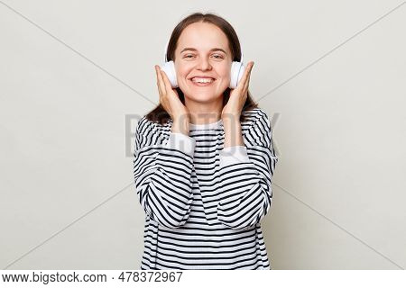 Smiling Happy Cheerful Young Woman Wearing Striped Shirt Listening To Music In Headphones Isolated O