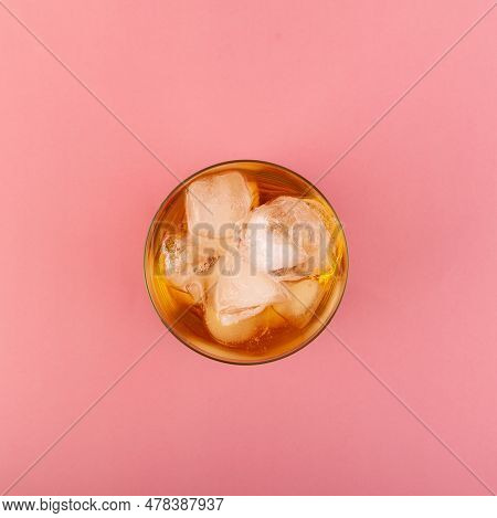 Glass Of Apple Spritzer Or Apfelschorle On Pink Background, Top View. Homemade Spritzer With Ice Cub