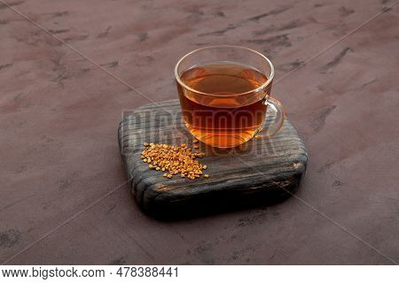 Helba Drink Or Fenugreek Yellow Tea On Wooden Board On Brown Background. Methi Dana Drink. Herbal Te