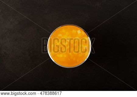 Glass Of Mango Yuzu Drink With Coconut Jelly On Dark Textured Background, Top View. Fruit Iced Lemon