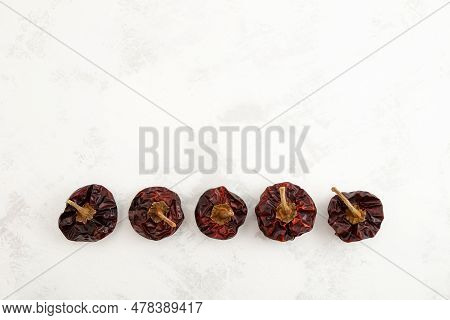 Row Of Dried Spanish Nora Peppers On Grey Textured Background. Top View, Copy Space.