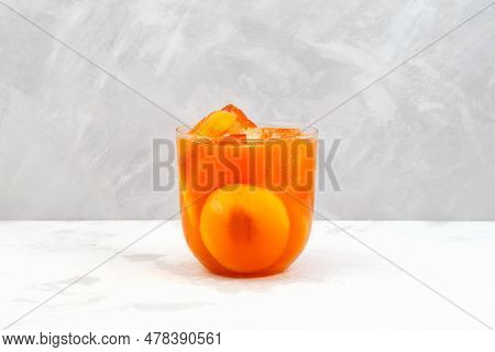 Glass Cup Of Tropical Cocktail With Natural Mango Juice, Fruit Pulp And Peach Pieces. Healthy Breakf