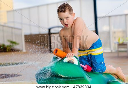 Bambino che gioca con il giocattolo di acqua presso la piscina per bambini durante l'estate