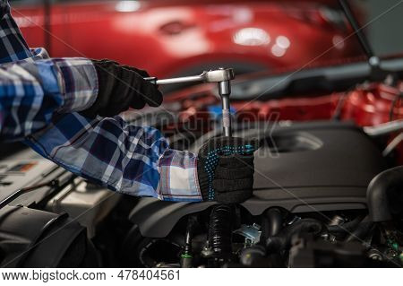 Female Auto Mechanic Unscrewing A Nut To Replace A Car Spark Plug.