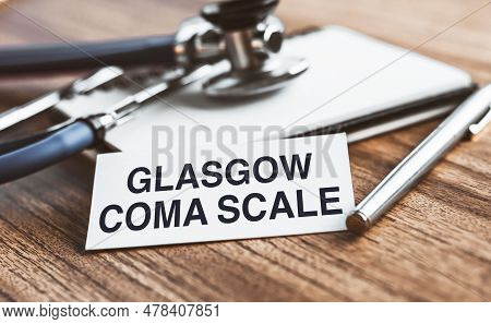 Glasgow Coma Scale - Text On White Sheet On A Wooden Background With A Stethoscope. Medical Concept