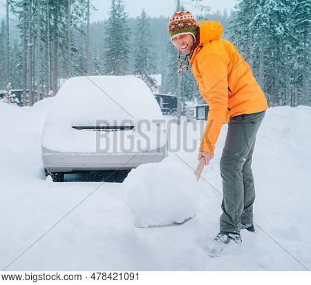 Smiling Man With A Shovel Removing Snow From The Path And Cleaning Auto. Car Covered With Snow As A 