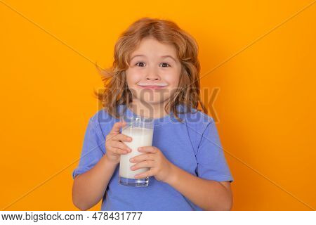 Kid Drink Fresh Milk. Beautiful Smiling Child With A Glass Of Milk. Cute Boy In Blue Shirt Holding G