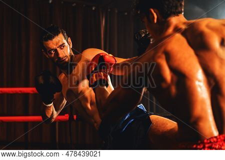 Asian And Caucasian Muay Thai Boxer Unleash Kick Attack In Fierce Boxing Match. Thai Boxer With Stro