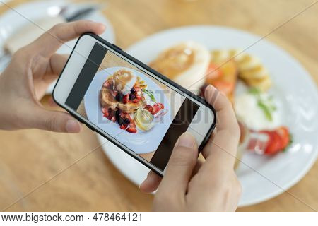 Restaurant Owner Takes A Picture Of The Food On The Table With A Smartphone To Post On A Website. On