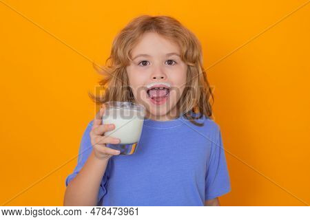 Dairy Milk. Portrait Of Child Drinking Milk, Yellow Isolated Studio Background. Kid With Glass Of Mi