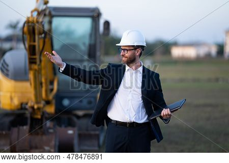 Construction Manager In Suit And Helmet At A Construction Site. Construction Manager Worker Or Super