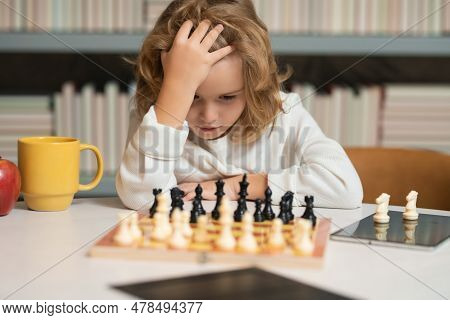 Kid Thinking Of Chess. Little Child Play Chess. Kid Playing Board Game. Thinking Child Brainstorming