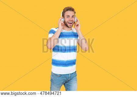 Amazed Estudy Man Takes An Online Course In Studio. Estudy Man Uses Headphones Isolated On Yellow Ba
