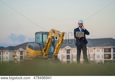 Construction Manager In Suit And Helmet At A Construction Site. Construction Manager Worker Or Super