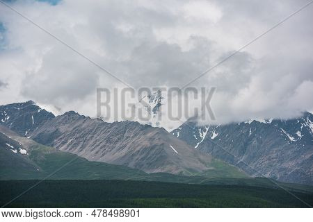 Dramatic Aerial View To Large Snow Mountain Range Under Rainy Cloudy Sky. Dark Atmospheric Alpine Sc