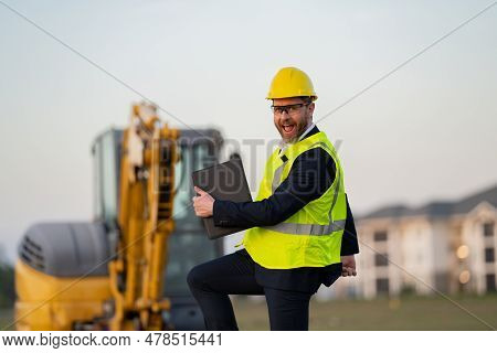 Construction Manager In Suit And Helmet At A Construction Site. Construction Manager Worker Or Super