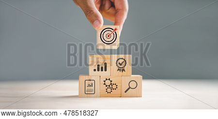 Wood Block Stacking Arranged By A Hand, Representing A Business Strategy And Action Plan. Targeting 