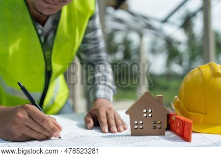 Engineers Man Recheck And Review The Blueprint Of Construction. Contractor Inspection Drawing Before