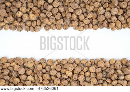 Top View Of A Of Tigernuts On A White Background With Copy Space In The Middle