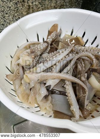 A Photography Of A Bowl Of Squids And Onions On A Table, There Is A Bowl Of Squid And Other Food On 