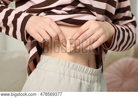 Woman Applying Contraceptive Patch Onto Her Body Indoors, Closeup