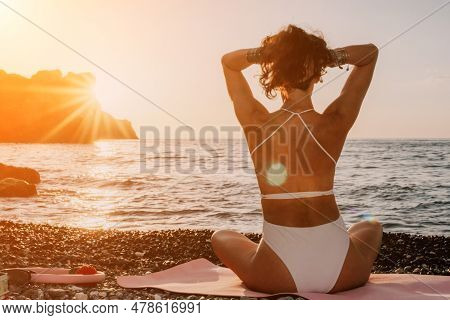 Woman Sea Yoga. Happy Woman In White Swimsuit And Boho Style Braclets Practicing Outdoors On Yoga Ma