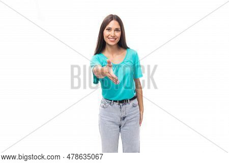 Young Sad Brunette European Lady With Straight Hair Dressed In A Blue T-shirt Holds Out Her Hand For