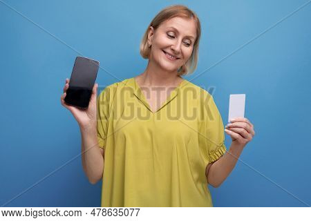 Blond Mature Woman Enjoys Online Credit Card Payments Using Smartphone
