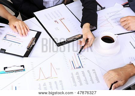 businesspartners hands during discussion of papers close up