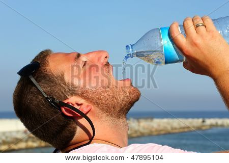 A Man Thirsty Eagerly Drinking Water From Plastic Bottle