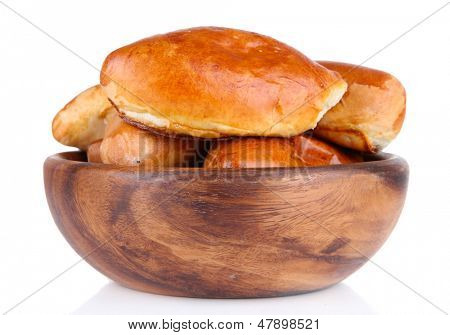 Empanadillas al horno frescas en un recipiente de madera, aislados en blanco