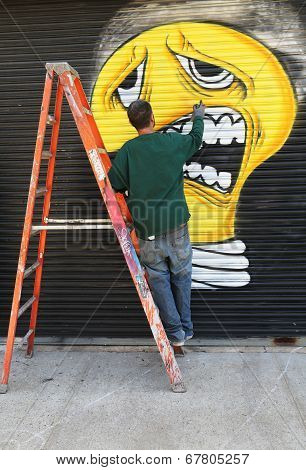 Street artist painting mural at Williamsburg in Brooklyn