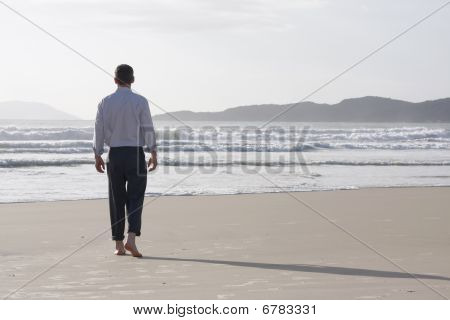 Biznesmen chodzenia boso po plaży