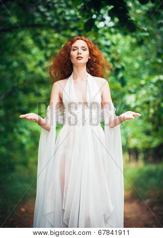 Gorgeous Red-haired Woman Wearing White Dress In A Garden
