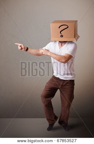 Young man standing and gesturing with a cardboard box on his head with question mark