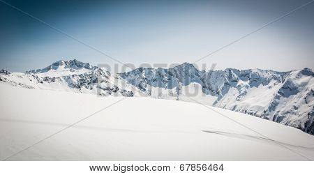 Snow Covered Slope With Mountain Ridge In The Back